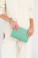 Profile view of model wearing the Oroton Eve Medium Pouch in Sage Green and Pebble leather for Women