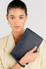 Profile view of model wearing the Oroton Eve Medium Pouch in Dark Navy and Pebble leather for Women