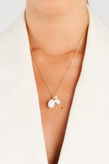 Profile view of model wearing the Oroton Kimberley Pearl Charm Necklace in Gold/Pearl and Brass for Women
