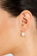 Profile view of model wearing the Oroton Kimberley Pearl Hook Earrings in Gold/Pearl and Brass for Women