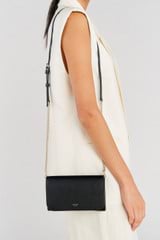 Profile view of model wearing the Oroton Georgia Wallet Clutch in Black and Saffiano Leather for Women