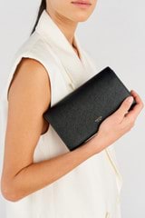 Profile view of model wearing the Oroton Georgia Wallet Clutch in Black and Saffiano Leather for Women