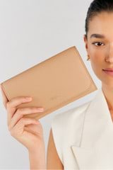 Profile view of model wearing the Oroton Georgia Wallet Clutch in Praline and Saffiano Leather for Women