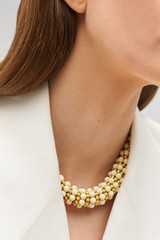 Profile view of model wearing the Oroton Pietra Necklace in 18K Worn Gold/Clotted Cream and Brass for Women