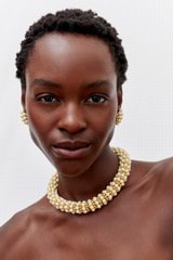 Profile view of model wearing the Oroton Pietra Necklace in 18K Worn Gold/Clotted Cream and Brass for Women