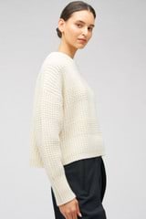 Profile view of model wearing the Oroton Stitched Crew in Cream and 100% merino wool for Women