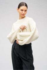 Profile view of model wearing the Oroton Stitched Crew in Cream and 100% merino wool for Women