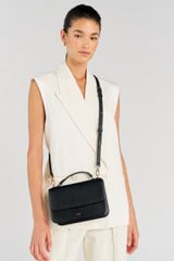 Profile view of model wearing the Oroton Lola Crossbody in Black and Textured Leather for Women