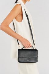 Profile view of model wearing the Oroton Lola Crossbody in Black and Textured Leather for Women