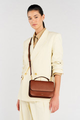 Profile view of model wearing the Oroton Lola Crossbody in Cognac and Textured Leather for Women