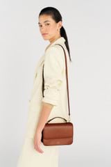 Profile view of model wearing the Oroton Lola Crossbody in Cognac and Textured Leather for Women