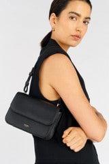 Profile view of model wearing the Oroton Lola Clutch in Black and Textured Leather for Women