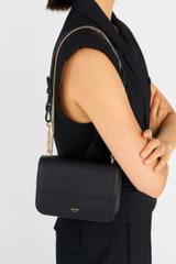 Profile view of model wearing the Oroton Lola Clutch in Black and Textured Leather for Women