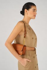 Profile view of model wearing the Oroton Lola Clutch in Cognac and Textured Leather for Women
