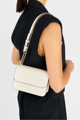 Profile view of model wearing the Oroton Lola Clutch in Cream and Textured Leather for Women