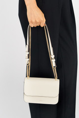 Profile view of model wearing the Oroton Lola Clutch in Cream and Textured Leather for Women