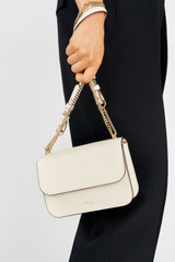 Profile view of model wearing the Oroton Lola Clutch in Cream and Textured Leather for Women