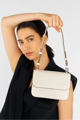 Profile view of model wearing the Oroton Lola Clutch in Cream and Textured Leather for Women