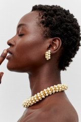 Profile view of model wearing the Oroton Pietra Earrings in 18K Worn Gold/Clotted Cream and Brass for Women