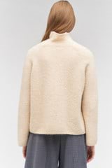 Profile view of model wearing the Oroton Soft Roll Knit in Camel and 16% mohair, 42% wool, 40% nylon, 2 % spandex for Women