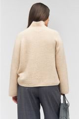 Profile view of model wearing the Oroton Soft Roll Knit in Camel and 16% mohair, 42% wool, 40% nylon, 2 % spandex for Women