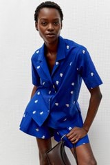 Profile view of model wearing the Oroton Embroidered Fruit Camp Shirt in Azure Blue and 100% cotton for Women