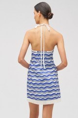 Profile view of model wearing the Oroton Wave Print Halter Dress in Azure Blue and 100% linen for Women
