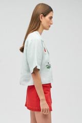 Profile view of model wearing the Oroton Embroidered Flower Camp Shirt in Eau De Nil and 100% linen for Women