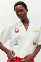Profile view of model wearing the Oroton Embroidered Flower Camp Shirt in Antique White and 100% linen for Women