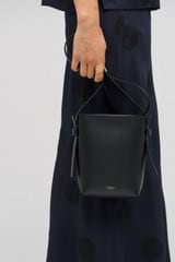 Profile view of model wearing the Oroton Ellis Crossbody in Black and Smooth leather for Women