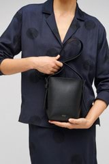 Profile view of model wearing the Oroton Ellis Crossbody in Black and Smooth leather for Women