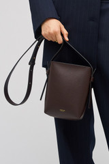 Profile view of model wearing the Oroton Ellis Crossbody in Mahogany and Smooth leather for Women