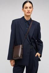 Profile view of model wearing the Oroton Ellis Crossbody in Mahogany and Smooth leather for Women