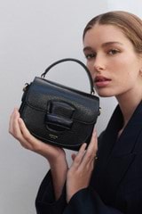 Profile view of model wearing the Oroton Carter Texture Mini Day Bag in Black and Embossed leather for Women