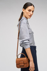 Profile view of model wearing the Oroton Carter Mini Day Bag in Brandy and Smooth leather for Women