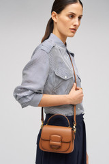 Profile view of model wearing the Oroton Carter Mini Day Bag in Brandy and Smooth leather for Women