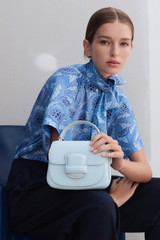 Profile view of model wearing the Oroton Carter Mini Day Bag in Glacier and Smooth leather for Women