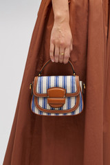 Profile view of model wearing the Oroton Carter Canvas Mini Day Bag in Natural / Blue Stripe and Canvas and leather trims for Women