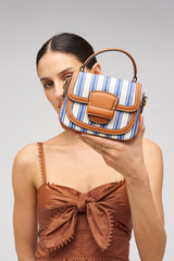 Profile view of model wearing the Oroton Carter Canvas Mini Day Bag in Natural / Blue Stripe and Canvas and leather trims for Women