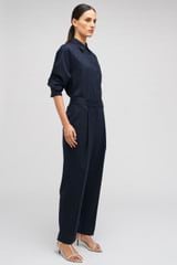 Profile view of model wearing the Oroton Tapered Pinstripe Pant in North Sea and 95% WOOL 5% ELASTANE for Women