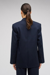 Profile view of model wearing the Oroton Pinstripe Blazer in North Sea and 95% WOOL 5% ELASTANE for Women