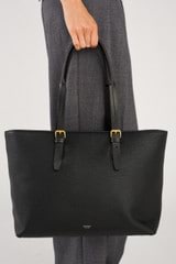 Profile view of model wearing the Oroton Dylan Large Tote in Black and Pebble leather for Women