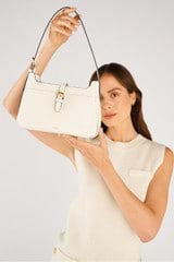 Profile view of model wearing the Oroton Dylan Baguette in Cream and Pebble Leather for Women