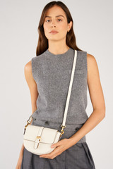 Profile view of model wearing the Oroton Dylan Small Saddle Bag in Cream and  for Women