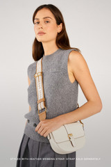 Profile view of model wearing the Oroton Dylan Small Saddle Bag in Cream and  for Women