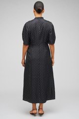 Profile view of model wearing the  Spot Print Day Dress in Black and 100% Silk for Men