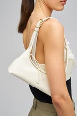 Profile view of model wearing the Oroton Cinder Mini Baguette in Antique Cream and Smooth Leather for Women