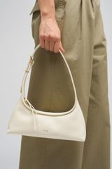 Profile view of model wearing the Oroton Cinder Mini Baguette in Antique Cream and Smooth Leather for Women