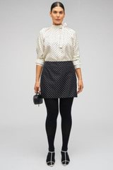 Profile view of model wearing the Oroton Spot Mini Skirt in Black/Cream and 100% Silk for Women