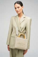 Profile view of model wearing the Oroton Lane Straw Tote in Laurel and Woven Straw With Leather Trim for Women